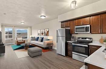 A modern kitchen with a refrigerator, oven, and microwave.
